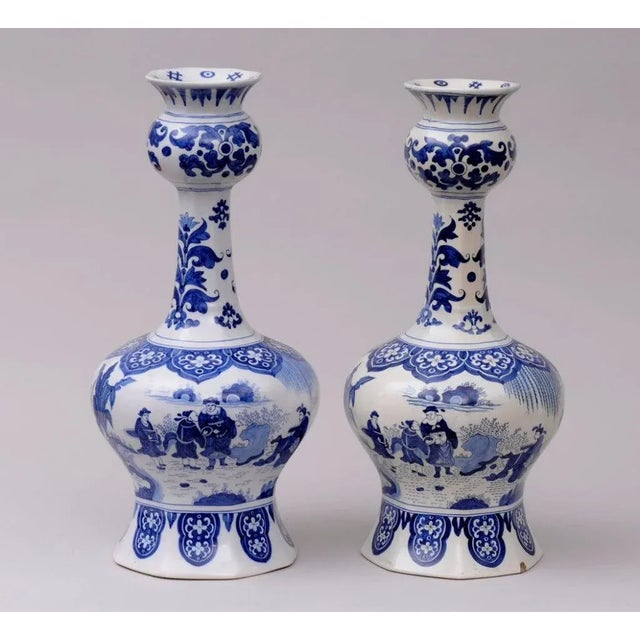 Pair of Dutch Delft blue and white onion bulb vases decorated with Chinese and European figures, horses, trees and hollow...