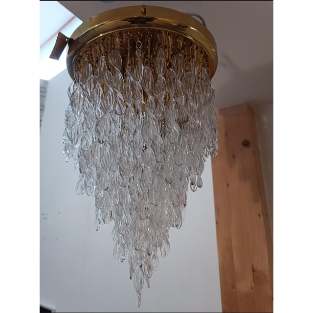 Sublime waterfall chandelier. Italy, 1970s. Brass base. Wavy Murano crystal pendants, suspended by brass chains. Beautiful...