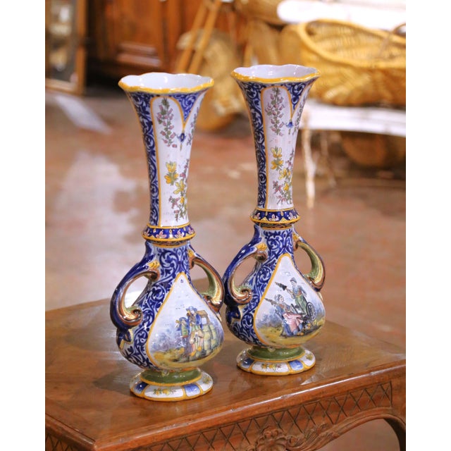 Crafted in Quimper, France circa 1880, this elegant pair of antique faience vases showcases the refined artistry of HB...