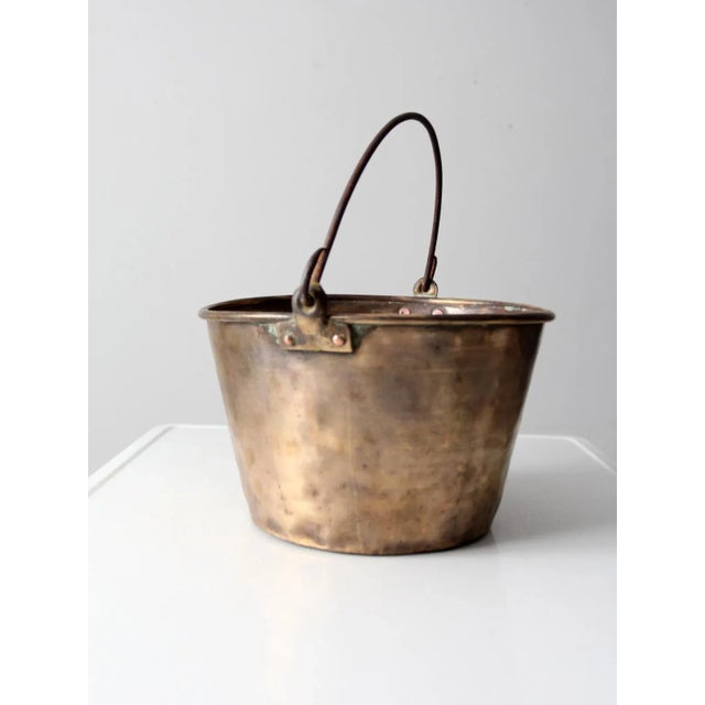 This is an antique brass fire bucket dating from the mid to late 19th century. The brass kettle features an iron bail...