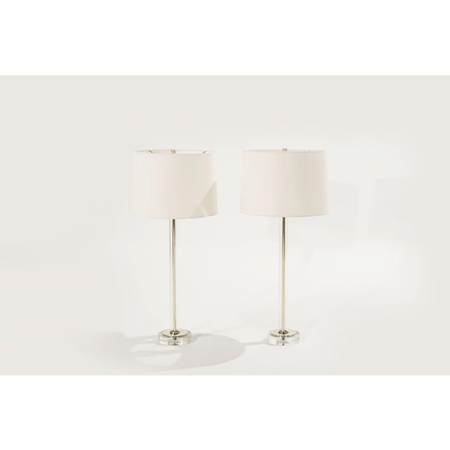 A gorgeous set of table lamps in the style of Charles Hollis-Jones, featuring a tubular glass stem, brass, and lucite...