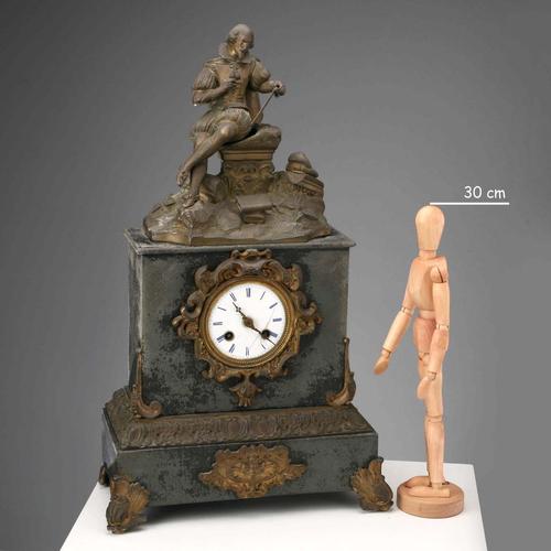 Table clock in gilded antimony with a dark patina, surmounted by a seated figure depicting the allegory of knowledge....