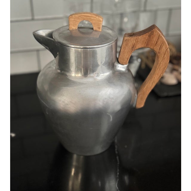 Rare early Club Aluminum coffee server from the 1930s–40s, featuring a sculptural cast-aluminum body and carved wood...