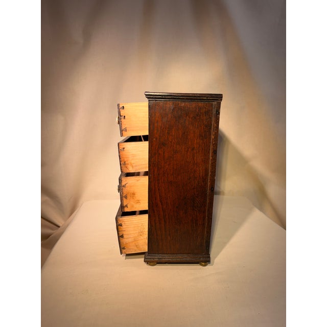 Antique small salesman sample of English oak chest with bone handles and escutcheons on small bun feet. Has pine interior....