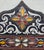 Vintage Moroccan hand‑painted mirror featuring an ornate arched frame adorned with colorful floral and geometric motifs....
