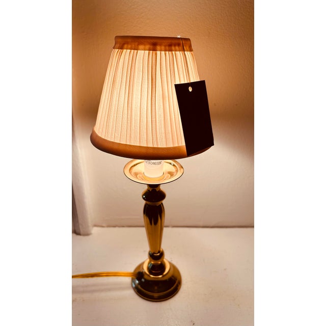 Small solid brass candlestick lamp with new cream color pleated clip on lamp shade. 12" tall to top of shade, 2.5" wide....