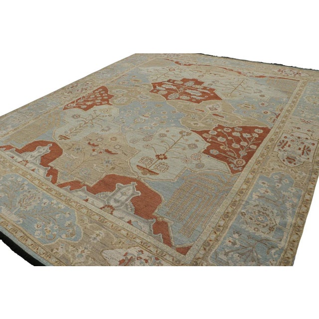 Hand knotted in wool, this 13x16 Burano rug in beige, red and blue tones with floral patterns and cartouches almost like...