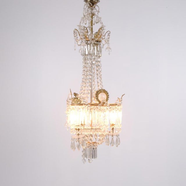 Exclusive antique chandelier from the 1890s, crafted with beautiful crystal prisms and decorative details in gilt bronze....
