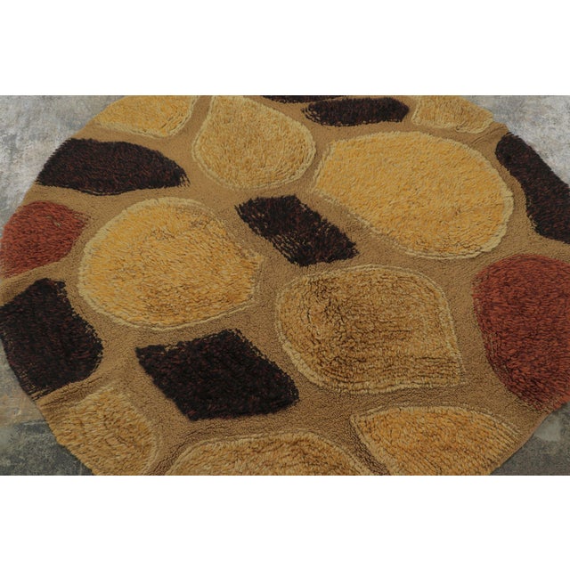 Hand knotted in wool and originating from Europe, circa 1950-1960, this 4x4 vintage circle rug enjoys an intricate, yet...