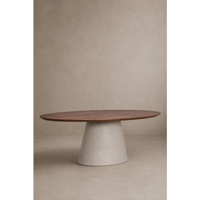 A table with a sculptural presence, where the warmth of solid wood meets the material simplicity of microcement. The oval...