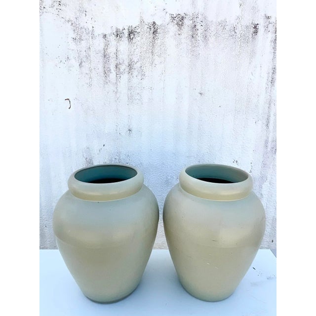 Vintage Contemporary pair of urns. Beautiful matte glazed finish in a pale green color. Drilled for draining. Part of a...