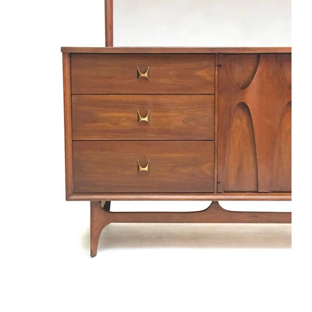 Lavish walnut coupled with brass accents make this triple dresser from Broyhill Brasilia Premier one of the finest...