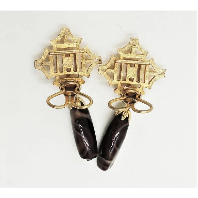 This is part of Chairish’s Costume Jewelry assortment. 1960s goldtone faux-brown agate with white swirls drop butterfly...