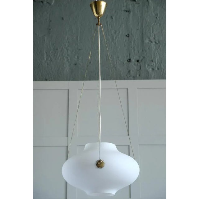 A rare brass & glass pendant designed by Carl Axel Acking, produced in Sweden, 1940s. This piece is attributed to the...