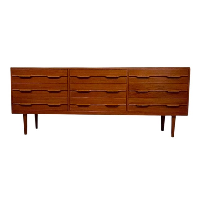This vintage mid century modern long dresser features a clean-lined Scandinavian-inspired design with warm wood tones and...