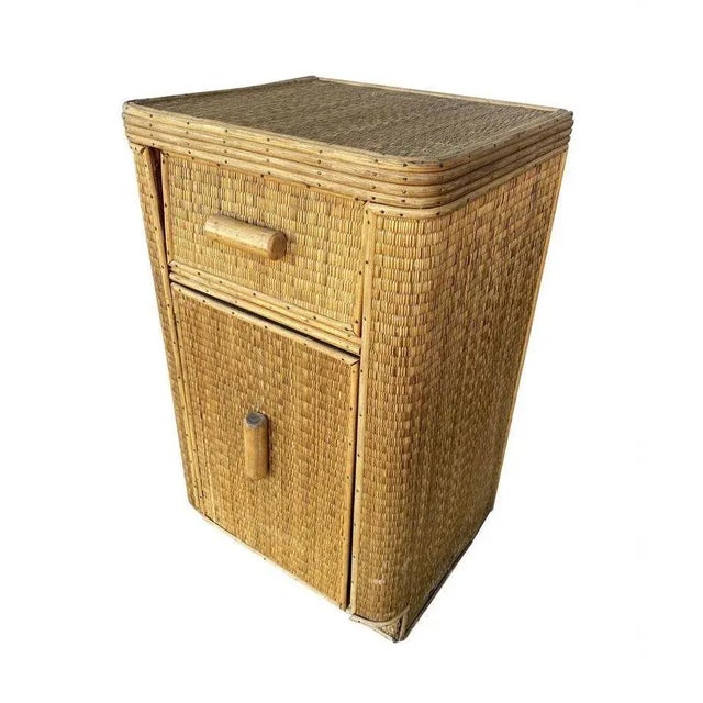 Streamline stick rattan side table nightstand with grass-mat coverings, edges are finished with brass nails. The side...