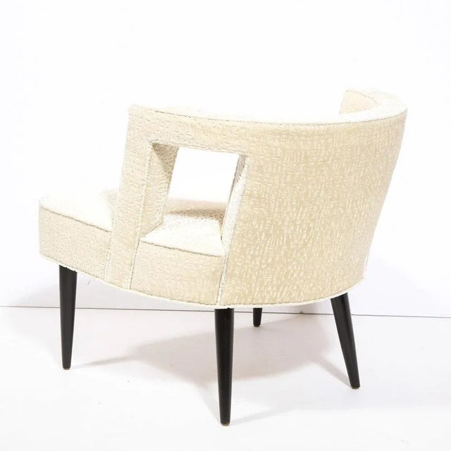 This graphic and sculptural arm chair was realized in the United States circa 1950. It features a barrel back with two...