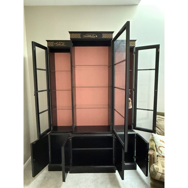 Vintage black lacquered Chinoiserie display cabinet / bookcase features hand painted landscape designs with exotic...