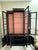 Vintage black lacquered Chinoiserie display cabinet / bookcase features hand painted landscape designs with exotic...