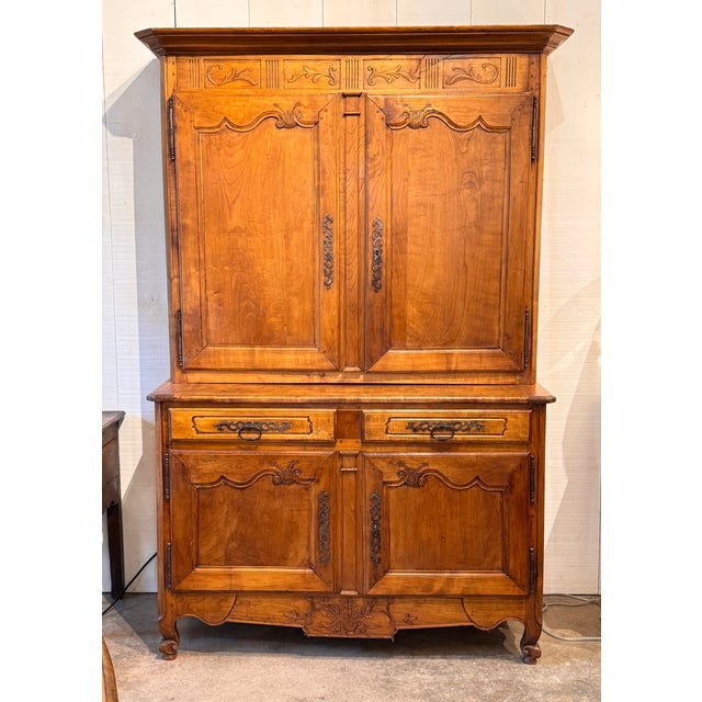 French Provincial cabinet featuring classic carved embellishments across the doors and apron, shaped panels, and original...