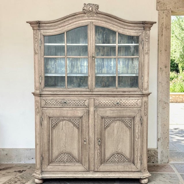 A true period 18th century Belgian bookcase cabinet in the Country French Regence style, carved by hand from solid oak and...