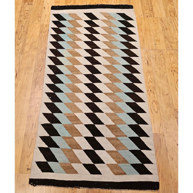 This exquisite vintage Navajo rug, dating from the mid-20th century, is a striking example of traditional Native American...