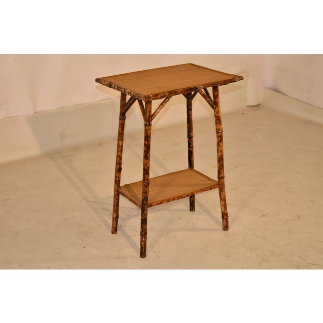 Late 19th century tortoise bamboo side table from France. The top is surrounded by a band of bamboo molding. The table is...