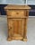 This early 1900s solid pine nightstand features a warm natural finish, paneled construction, turned side columns, and...
