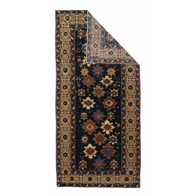 This is one of the most iconic of Caucasian rug patterns. The nearly navy field hosts a fall of “snowflakes” in reds,...