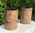 Pair of vintage cylindrical wastebaskets featuring detailed Egyptian Revival imagery with hieroglyphic motifs, figures,...