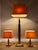 Set consisting of one floor lamp and two table lamps made of polished brass with geometric bases and cream fabric shades....