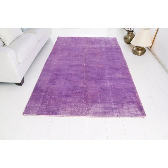 This is a vintage Turkish Oushak rug from the Mid 20th Century. The piece was hand-knotted.