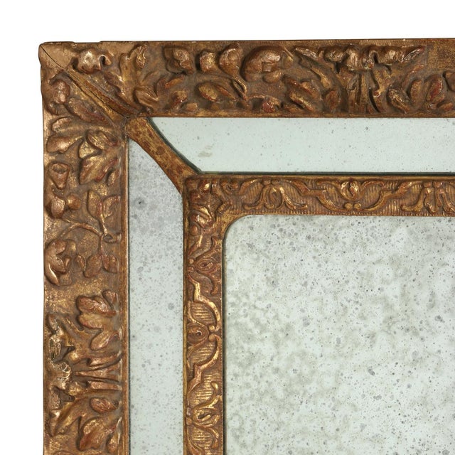 The sculptural gilt gesso frame mirror features an embossed, textural relief with a segmented mirrored border. The central...