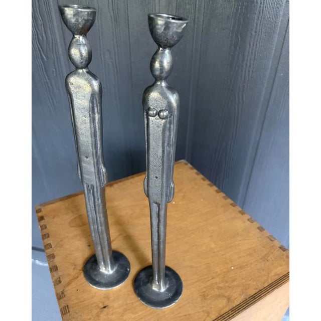 A striking and sophisticated pair of late-20th-century figurative candlesticks, heavily channeling the modernist...
