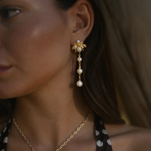 Celebrate elegance, abundance, and feminine strength with the Queen Bee Pearl & Diamond Earrings. Handcrafted with...