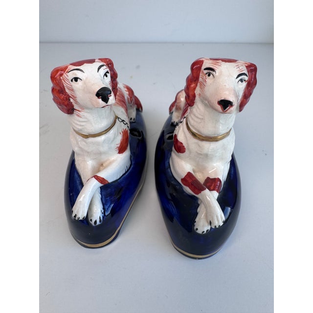 A charming pair of Staffordshire dogs with a bit of utility as a pen holder. The dogs rest atop a cobalt colored base with...