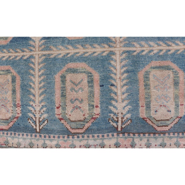 This vintage Turkish Tulu rug has been hand-knotted in wool and features an all-over sub-geometric medallion design...