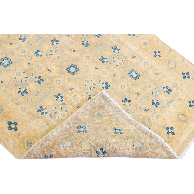 Beautiful vintage Persian distressed hand-knotted wool rug with a beige color field. This piece has blue accents in an...