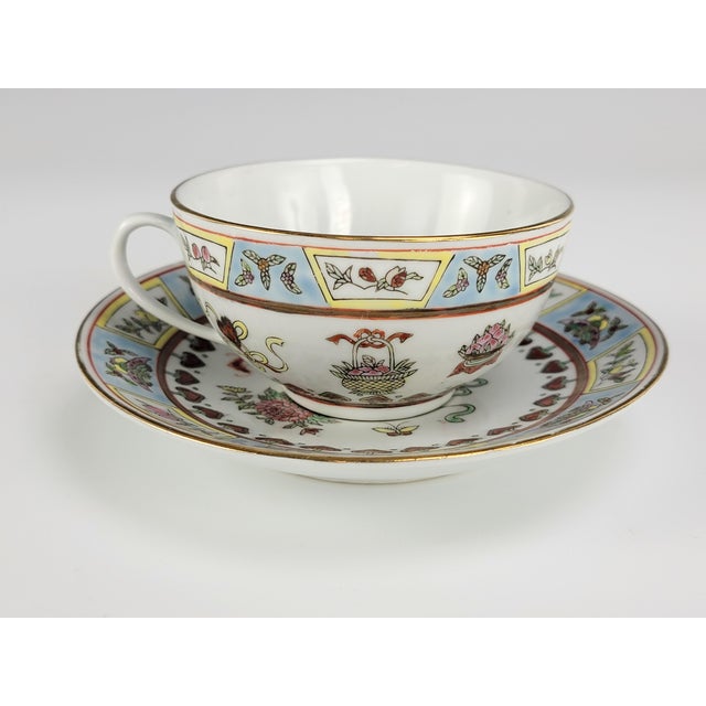 This Jingdezhen porcelain tea cup and saucer set is decorated in Guangcai style, featuring overglaze Famille-rose enamels...