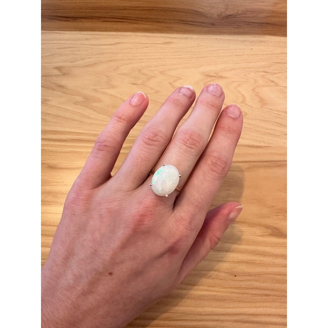 An opal takes centre stage in a shifting play of colour at the centre of this solid 14K yellow gold ring. No two opals are...