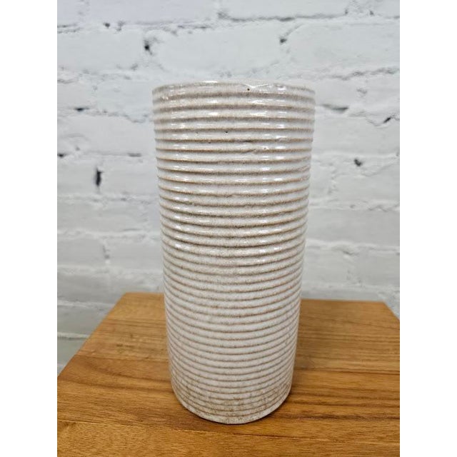 This is a mid-century modern ribbed cylinder vase from the Zanesville Stoneware Company (often referred to simply as...