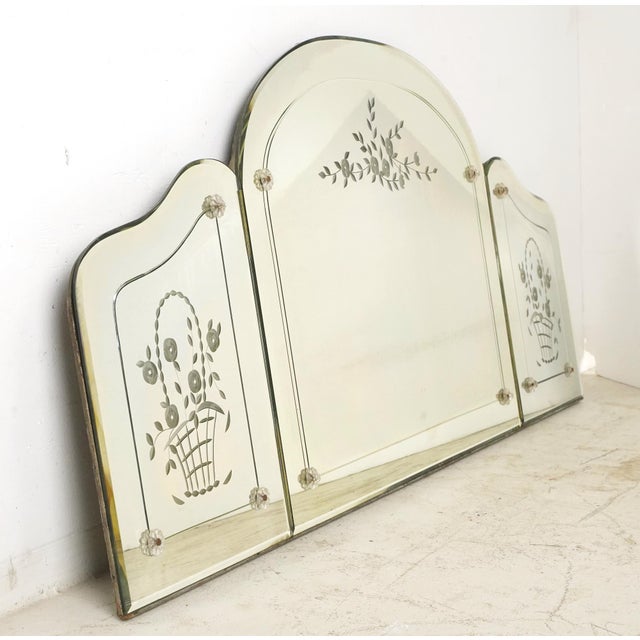 Traditional style frameless wall mirror constructed of three fixed panels with etched borders and flower basket motifs....