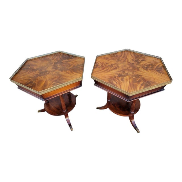 Elegant pair of 1920s English Regency end tables featuring Bookmatched mahogany tops, brass gallery trim, and curved saber...