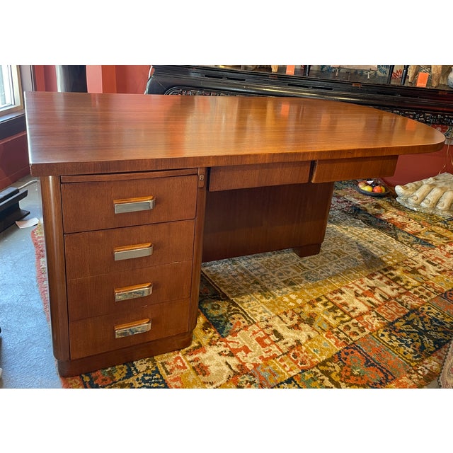 This 1930s Art Deco executive desk features a polished wood finish and distinctive chrome drawer pulls - It blends...