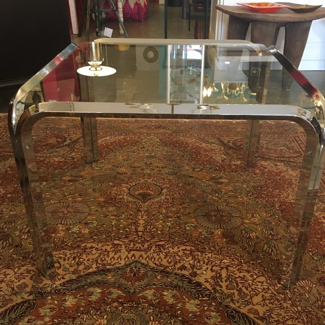 Great chrome and glass cocktail table from the 1970s. The chrome frame is 4 equal parts that include 2 legs each that are...