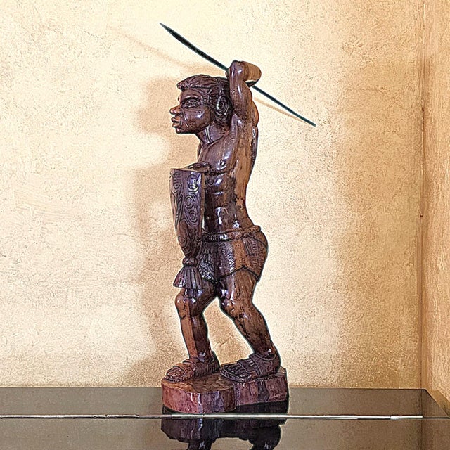 A commanding vintage hand-carved hardwood sculpture depicting an Igorot warrior from the northern Philippines. This...