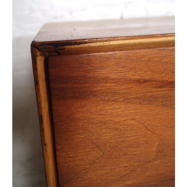 Gorgeous vintage modern low dresser featuring rich walnut grain, metal handles, brass pulls and nine drawers. Condition:...