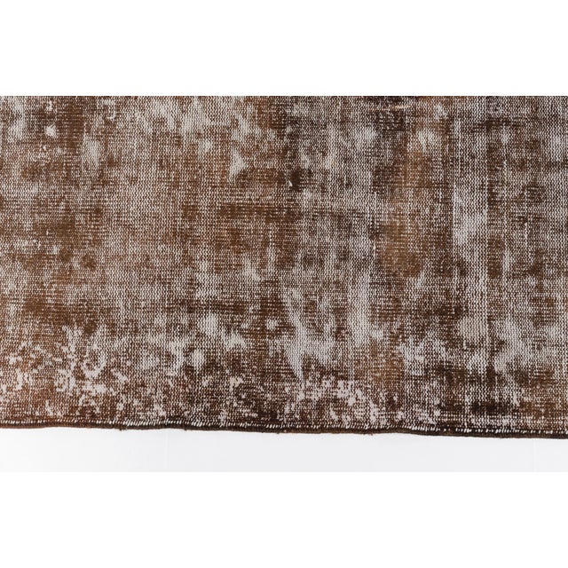 This is a vintage Turkish Oushak rug from the Mid 20th Century. The piece was hand-knotted.