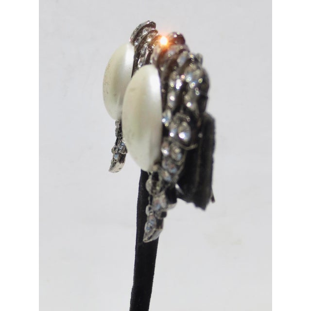 Triangular clip-on earrings with big faux pearls. Blackened enamel settings. Art Deco setting patterns. No markings are...