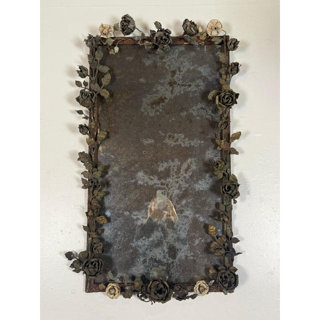 A striking and highly sculptural mid-century mirror framed in hand-forged wrought iron, adorned with dimensional roses,...